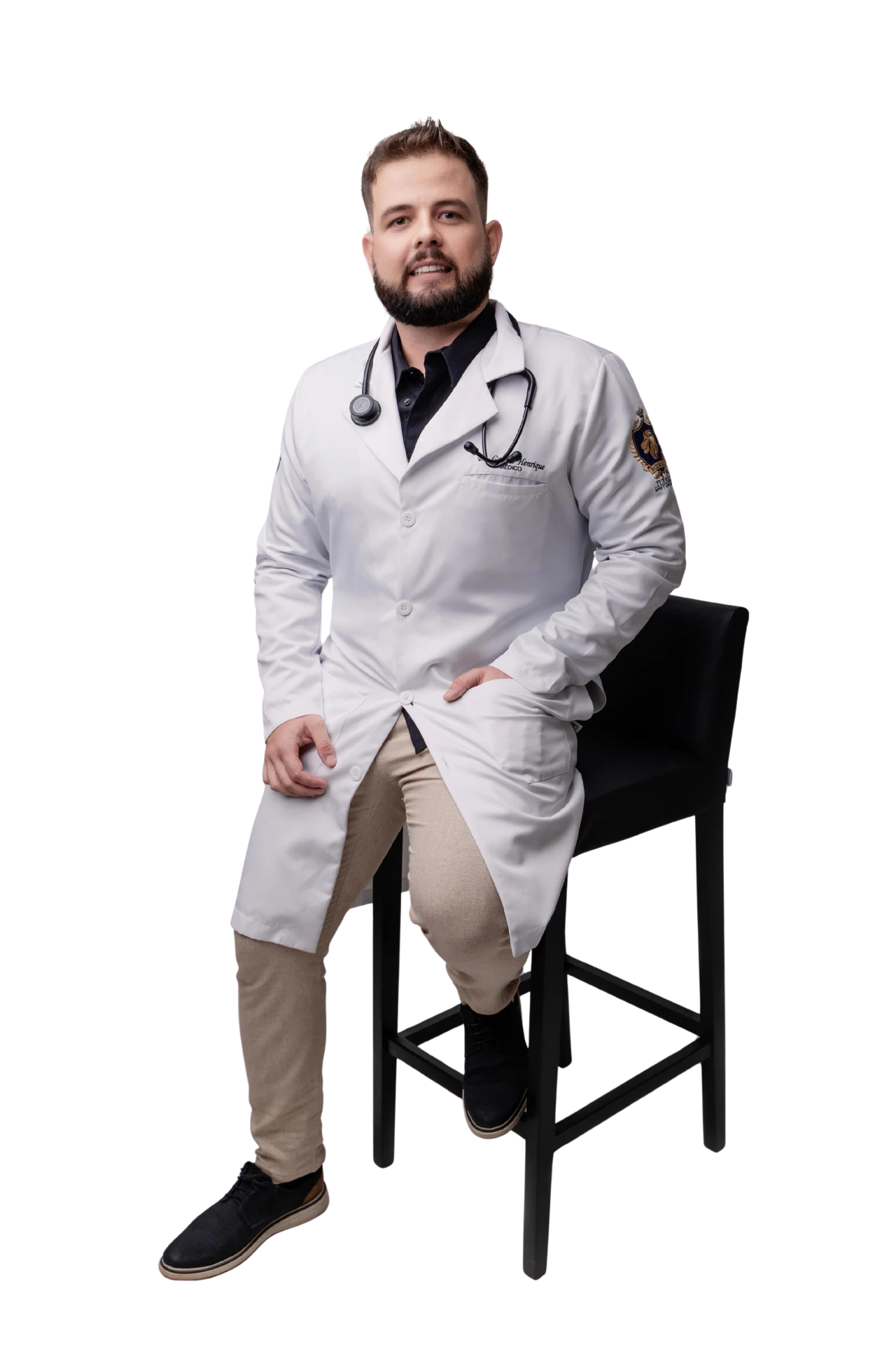 Dr. Gabriel Possamai apoiado em banqueta, de jaleco branco